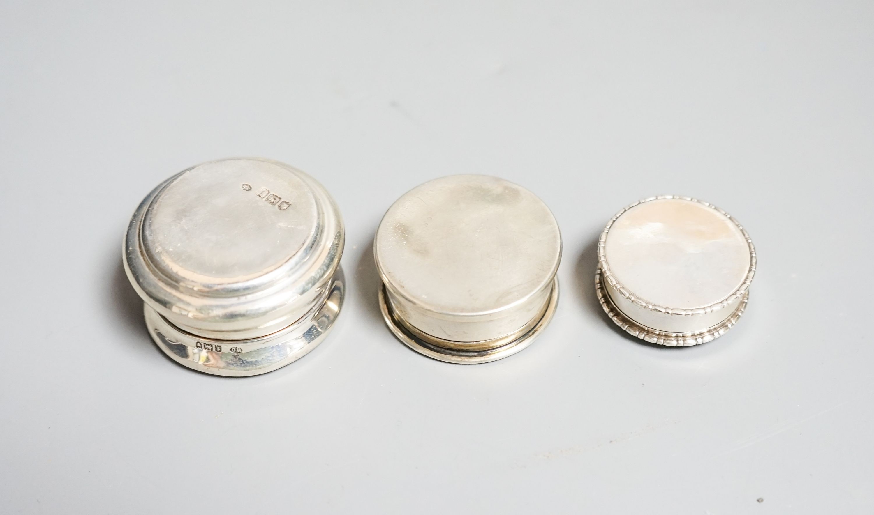 Three assorted early 20th century small silver and tortoiseshell pique circular boxes and covers, largest by William Comyns, 46mm.